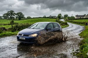 Car driving through rain and mud on Irish roads requiring paint protection
