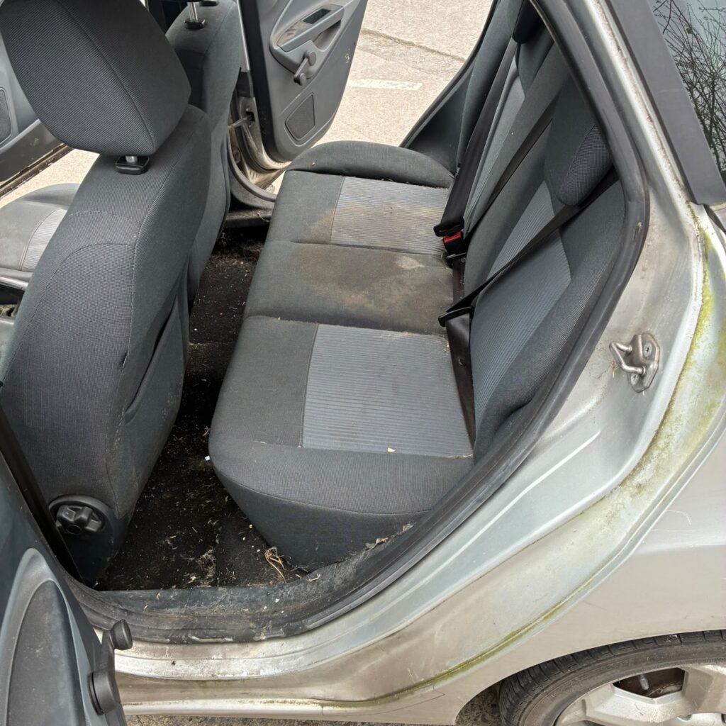 Stained rear cloth bench seat and muddy back footwells before Full Valet cleaning in the Adare area.