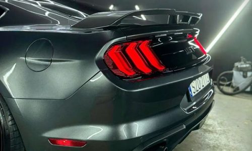 Advanced water-beading performance on the passenger-side rear bumper corner, displaying the finished 5-year automotive surface protection.