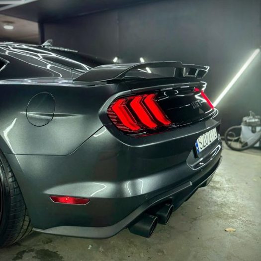 Advanced water-beading performance on the passenger-side rear bumper corner, displaying the finished 5-year automotive surface protection.