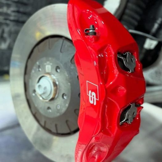 A close-up view of the complete caliper transformation: clean lines, custom color, sharp branding and a glossy, protective ceramic finish on a Robertstown and Allenwood sport car.