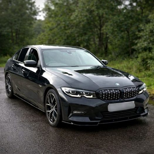 Gloss black executive sedan in Ireland, showcasing a newly installed front bumper lip splitter, sideskirts and matching gloss black kidney grilles.