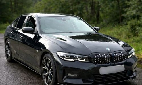 Gloss black executive sedan in Ireland, showcasing a newly installed front bumper lip splitter, sideskirts and matching gloss black kidney grilles.