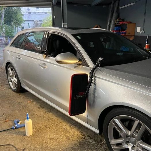 Precision dent removal on a side panel, restoring the factory lines without paint using specialised PDR lamps to identify and massage out minor surface imperfections. Specialist dent repair for high-end vehicles, serving North and South Dublin.