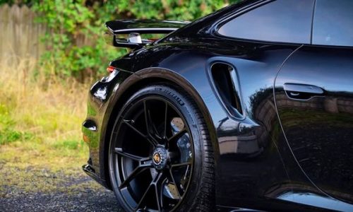 Close-up of gloss paintwork reflection on a black Porsche treated with ceramic coating.