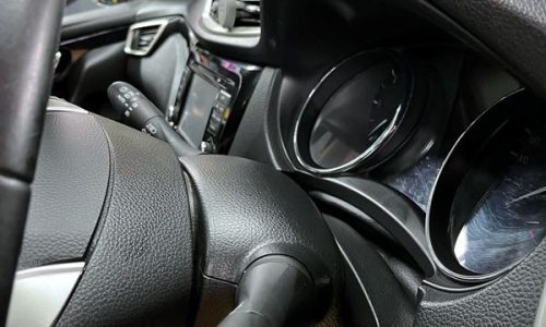 Precision dusting of the steering column and instrument cluster screen during a Silver Car Valet maintenance treatment.