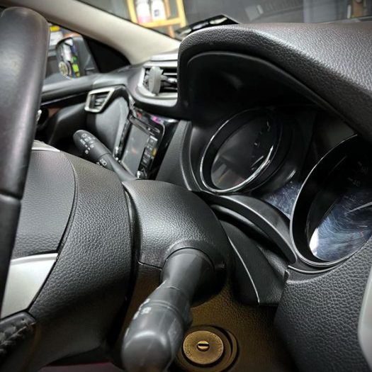 Precision dusting of the steering column and instrument cluster screen during a Silver Car Valet maintenance treatment.